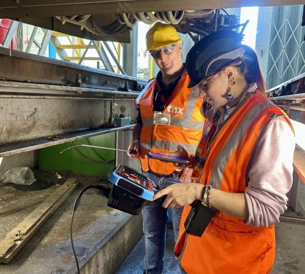 Two railway maintenance technicians inspect train bogie components with Yateks Realta 3D industrial endoscope at rolling stock depot