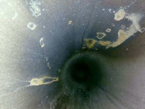 Dirty interior wall of aerospace cast metal oil pipeline with casting slag and residual impurities captured by industrial borescope